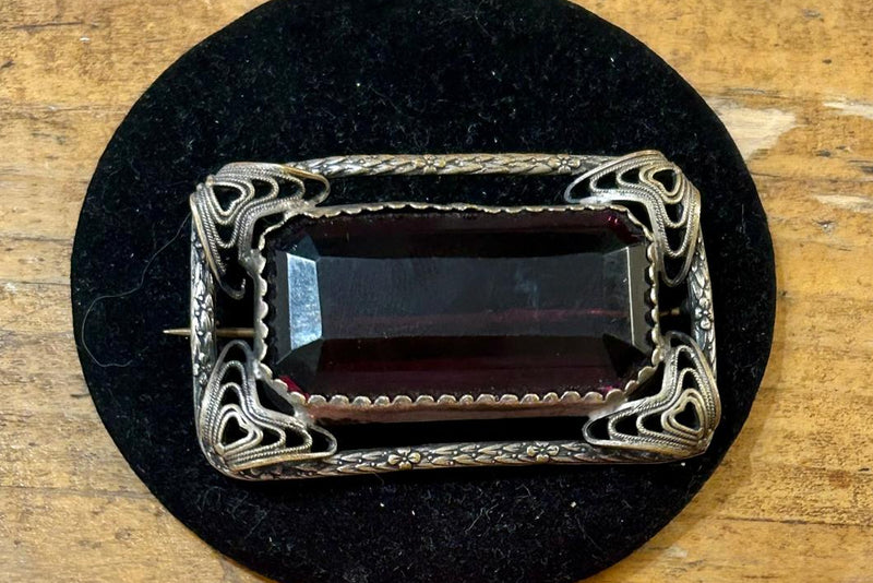 Vintage open work filigree Brooch with large rectangular emerald cut purple glass